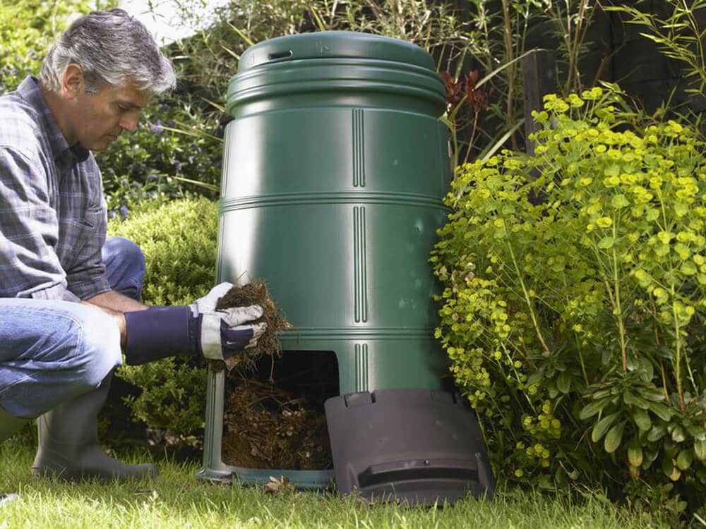 man removing compost from compost bin