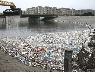 thousands of plastic bottles washed up on a riverbank