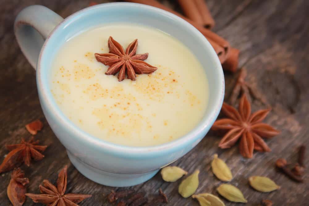 chai tea latte in a white mug with star anise floating on top