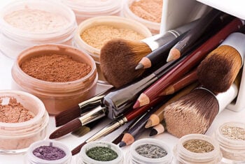 eyeshadows, eyeliners, powders, brushes and other make up on a countertop