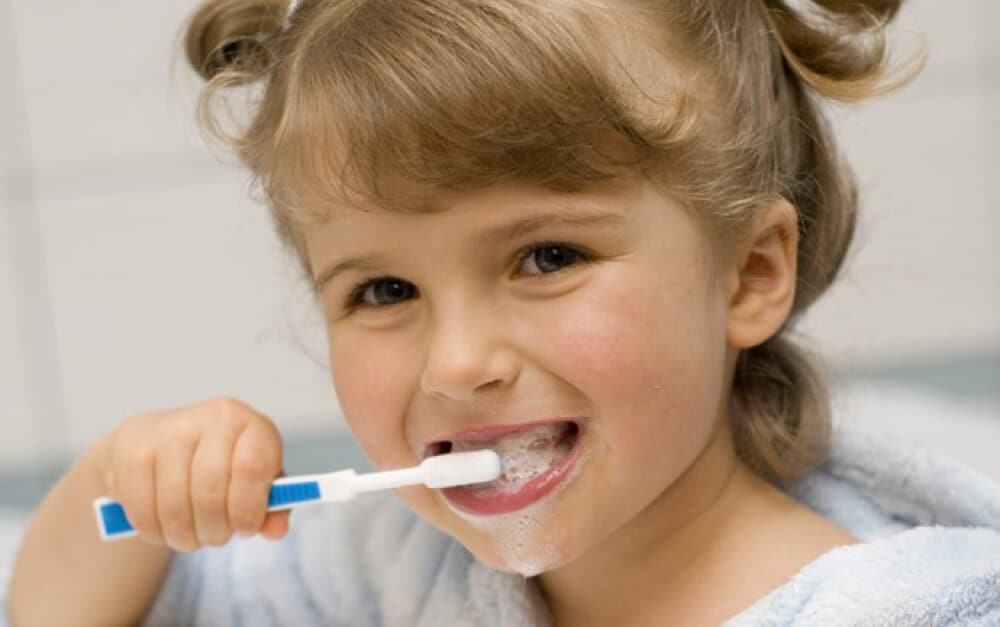 little girl brushing her teeth