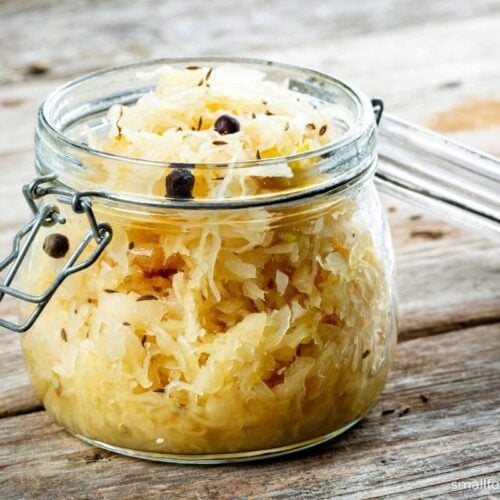 homemade sauerkraut in a glass canning jar on a wooden table