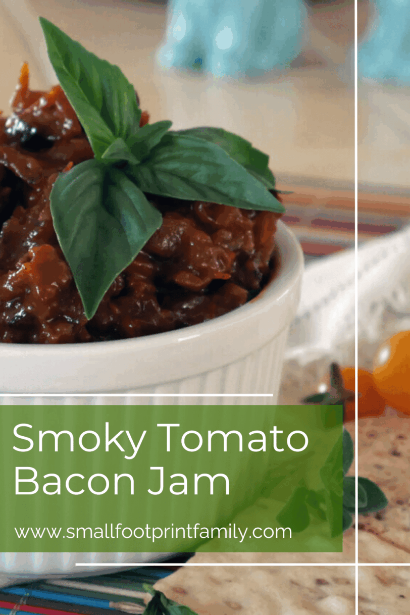 smoky tomato bacon jam in a white bowl with a basil garnish