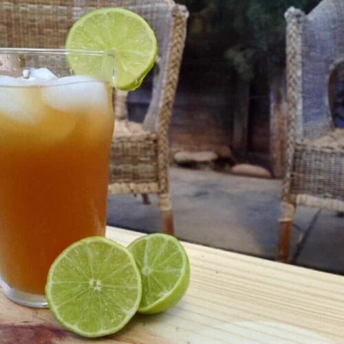 glass of honey sweetened limeade with sliced lime on a table