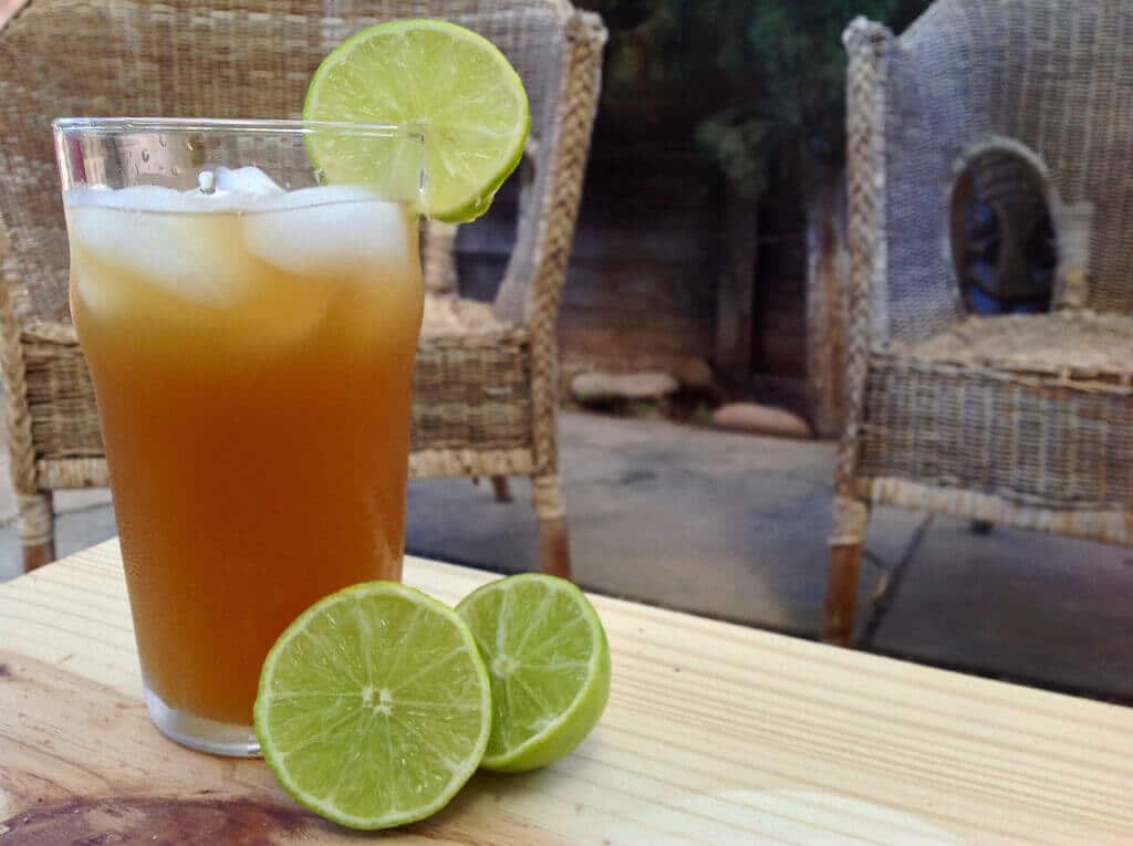 glass of honey sweetened limeade with sliced lime on a table