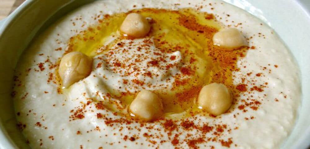 raw sprouted chickpea hummus with olive oil and paprika in a dish
